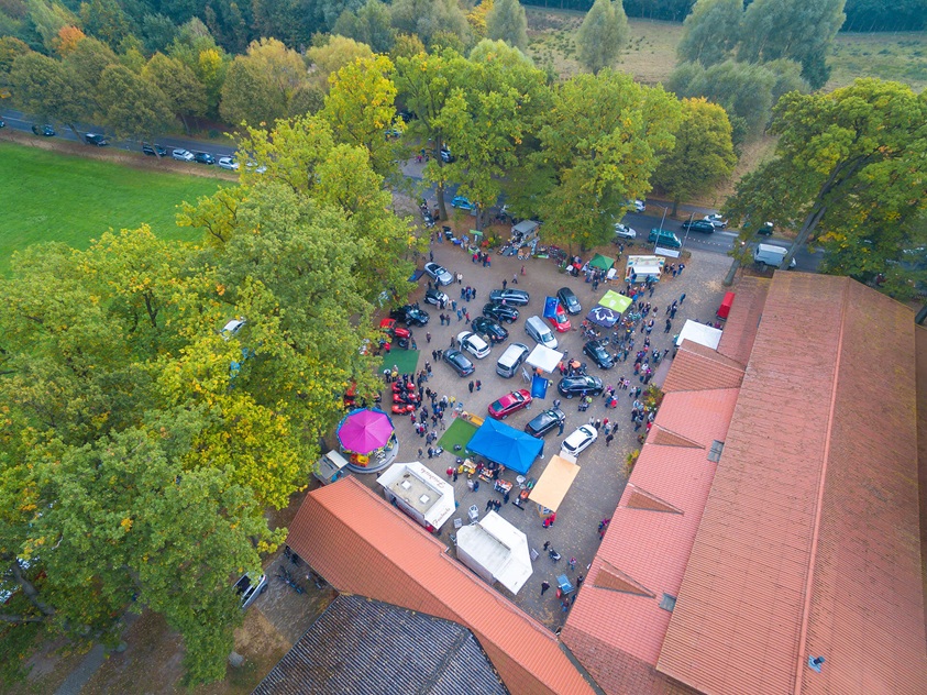 Drohnenaufnahme eines gut besuchten Marktes oder Events in Hankensbüttel mit Verkaufsständen und Besuchern.