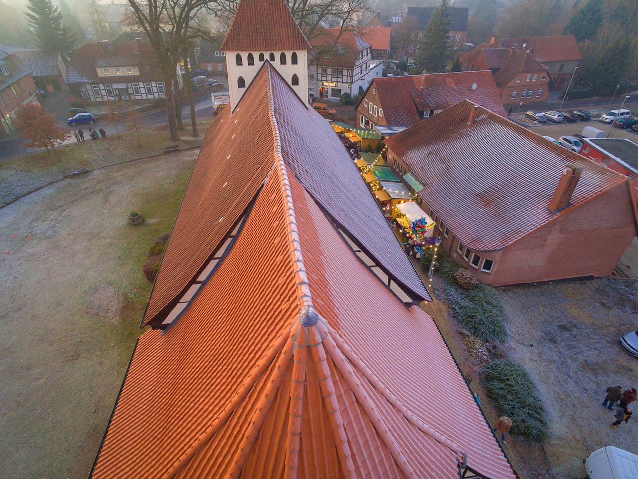 Nahaufnahme des Ziegeldachs der St. Pankratius-Kirche in Hankensbüttel mit Blick auf den Kirchplatz.