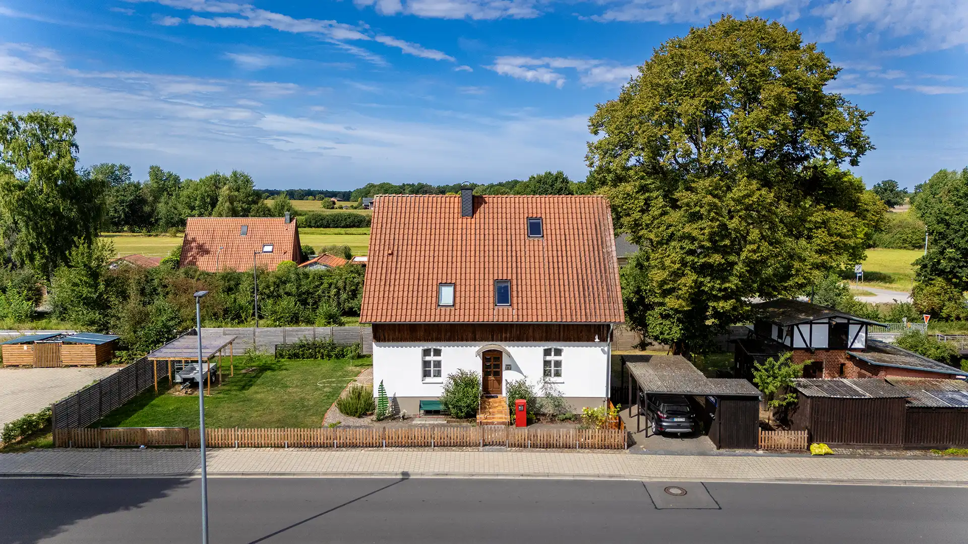 Luftbild eines privaten Wohnhauses mit Garten und großem Baum in Knesebeck