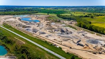 Luftaufnahme eines Kieswerks mit Fokus auf die Förderband-Infrastruktur und Sortieranlagen.