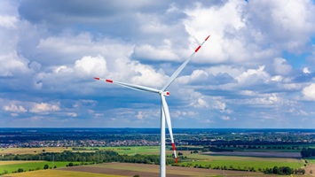 Beeindruckende Drohnenaufnahme einer Windkraftanlage über einer weiten Landschaft zur gewerblichen Nutzung und Präsentation.