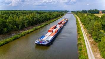 Drohnenflug über den Elbe-Seitenkanal bei Wittingen mit Sicht auf ein vorbeifahrendes Containerschiff.