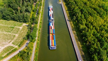 Hochauflösendes Luftbild eines Kanals mit Güterschiff zur Dokumentation von Verkehrswegen und Infrastrukturprojekten.