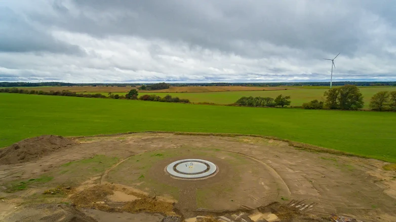 Fundament einer Windkraftanlage während der Bauphase mit umliegenden Feldern